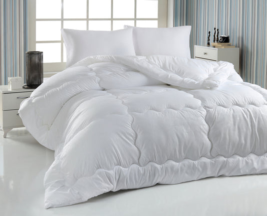 A white duvet and pillow on a bed.